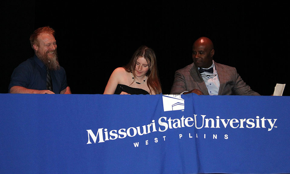 Summer Gabriel, center above, signs her paperwork with Grizzly eSports Coach Alex Pinnon, left, and MSU-WP Interim Athletics Director Crockett Oaks looking on. (MSU-WP Photo)&nbsp;